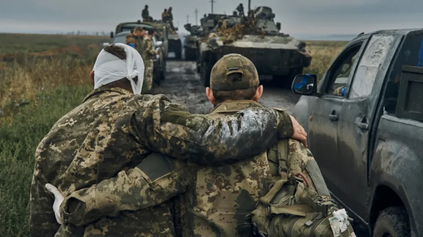 Soldier supporting injured Ukrainian soldier